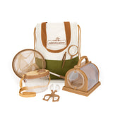 A collection of children's outdoor exploration tools including a telescopic bug net, a magnifying glass, tweezers, a clear plastic bug cage and container, along with a beige and green tote backpack.