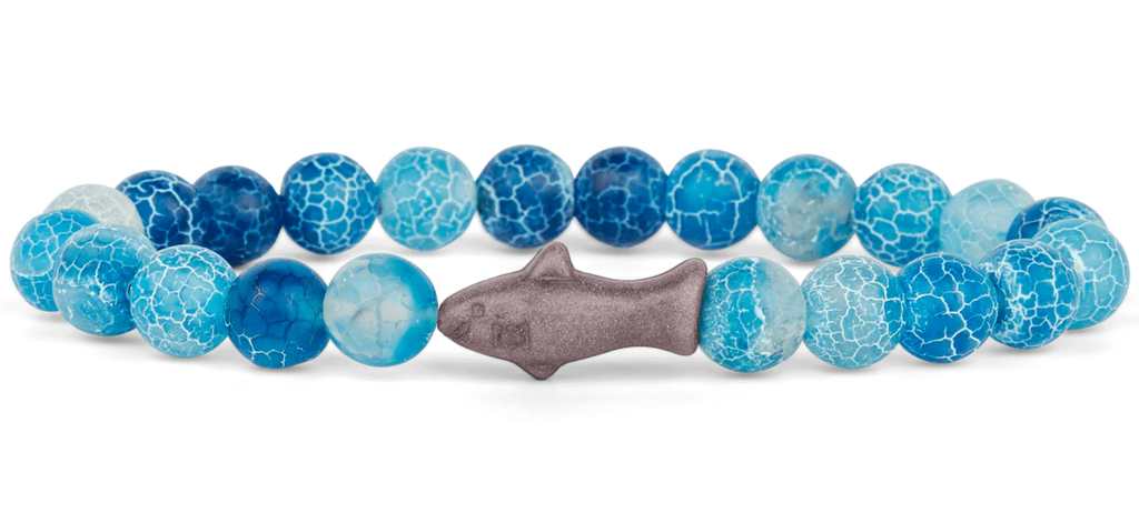 Bracelet with blue and gray beads and a fish-shaped charm on a white background