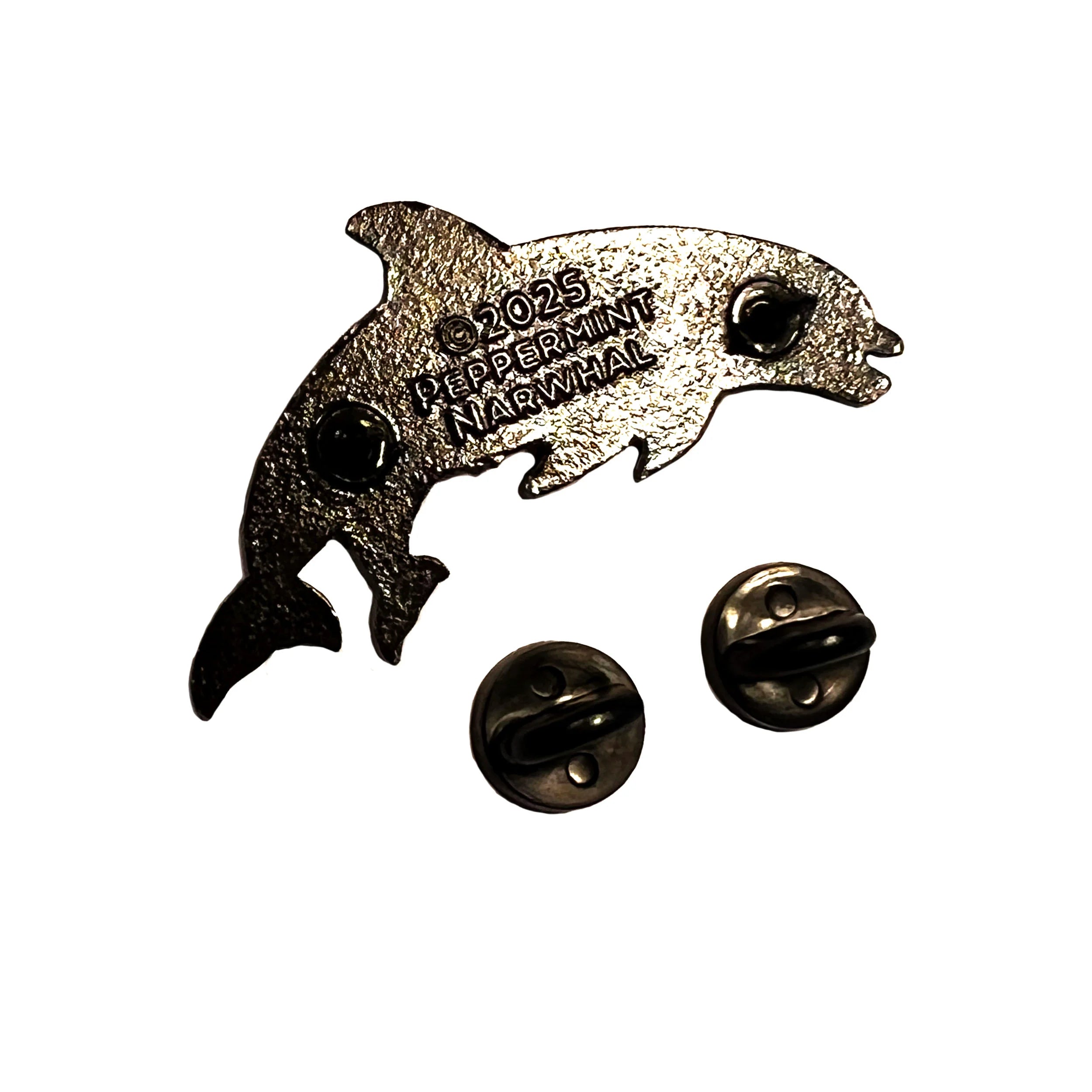 Metallic dolphin-shaped pin with '2023 Peppermint Marwhal' text on a white background