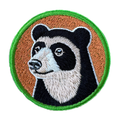Embroidered patch of a bear face with a brown background