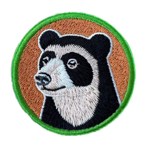 Embroidered patch of a bear face with a brown background