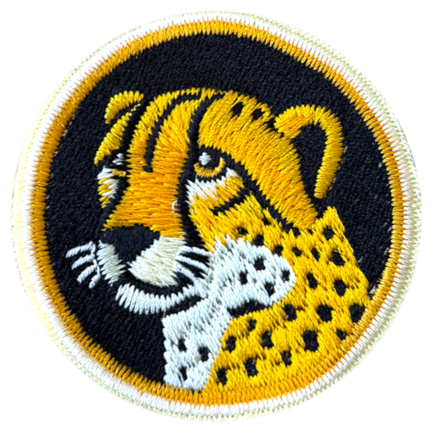 Embroidered patch of a cheetah head on a black background