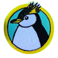 Embroidered patch of a penguin with a yellow border on a white background