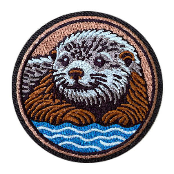Embroidered patch of an otter in a circular design with water background