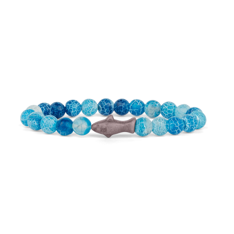 Blue beaded bracelet with a gray shark-shaped charm on a white background