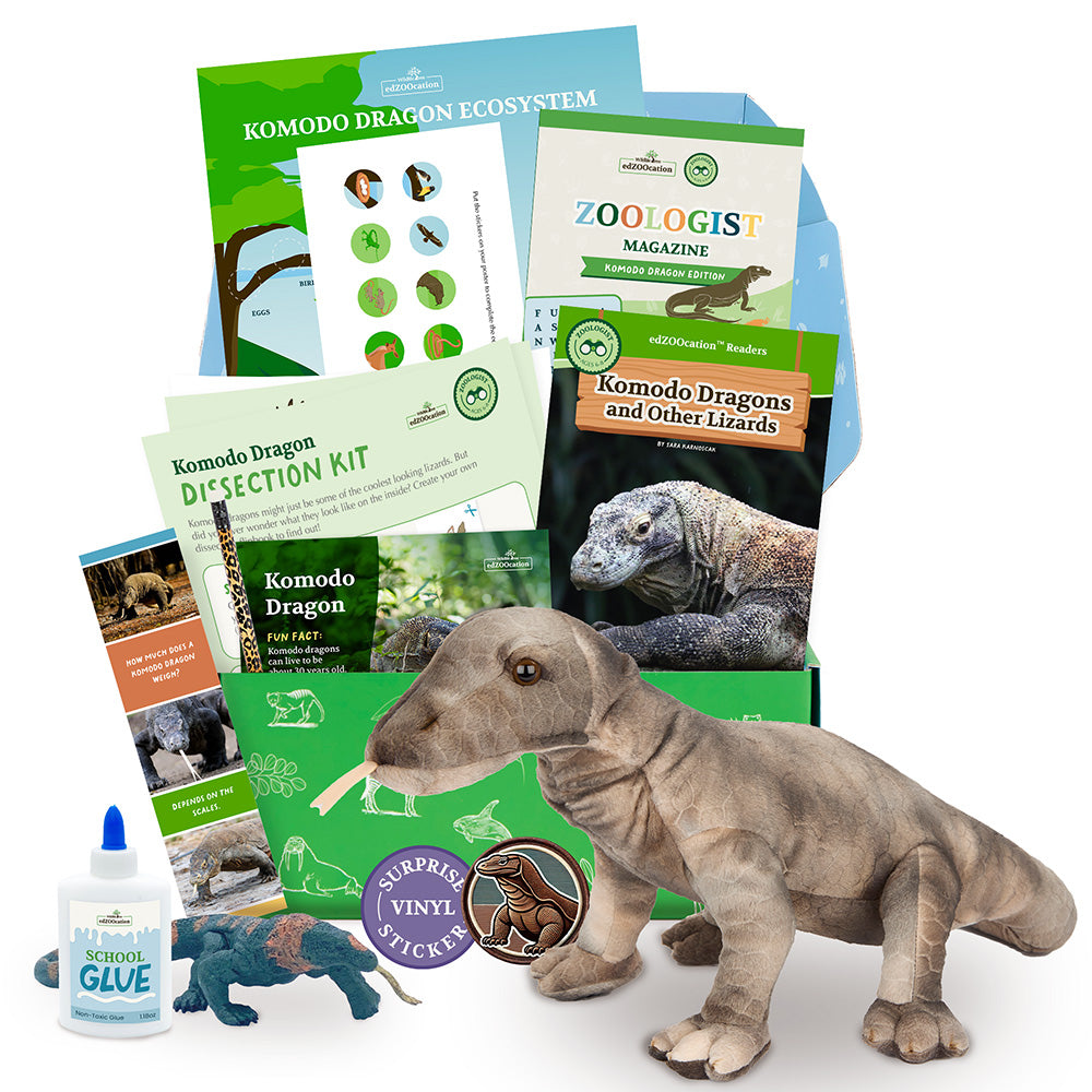 Assorted children's educational toys and books related to Komodo Dragons, including a stuffed animal, a craft item, a fact card, a bookmark, a writing prompt, a magazine, and a surprise item, all themed around zoology.